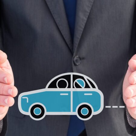 Digital composition of businessman protecting car icon against blue background